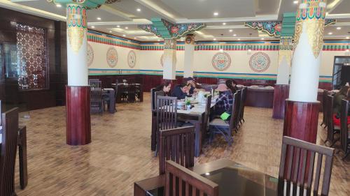 a restaurant with people sitting at tables in a room with columns at Hotel Paradise Ladakh in Leh