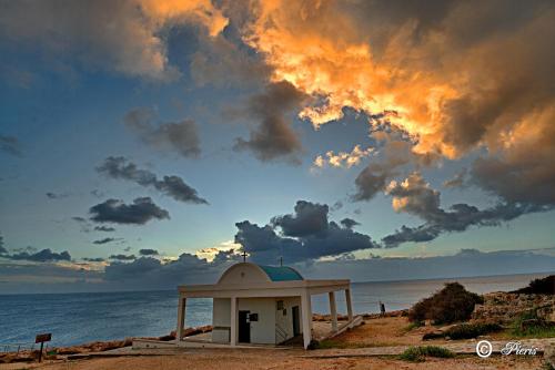 a small chapel on a beach with the ocean at Golden Tree Apartment in Paralimni