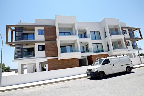 a white van parked in front of a building at Golden Tree Apartment in Paralimni