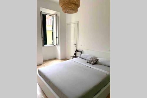 a white bedroom with a bed with a window at Piazza Anco Marzio fronte mare casa con giardino in Lido di Ostia