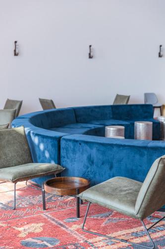 two chairs and a table in front of a blue wall at Enjoy Dead Sea Hotel in Ein Bokek