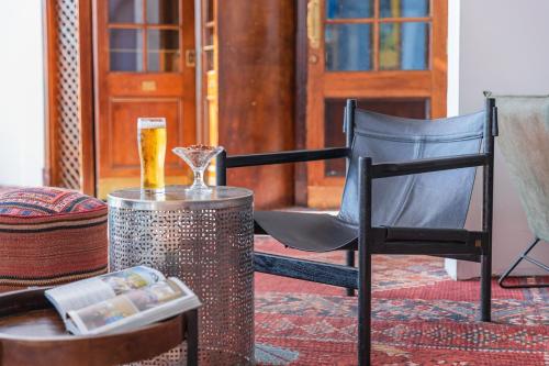 a glass of beer sitting on a table next to a chair at Enjoy Dead Sea Hotel in Ein Bokek