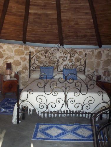 a bedroom with a large bed with blue pillows at Ovile Juanne Loddo in Orosei