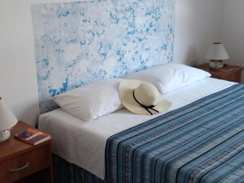 un sombrero sentado en la parte superior de una cama en casa Calaluna en Cala Gonone