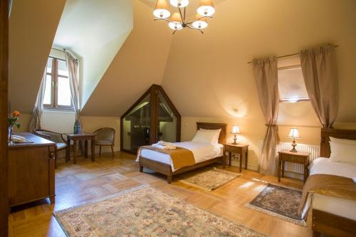 a bedroom with two beds and a chandelier at Pałac Polanka in Krosno