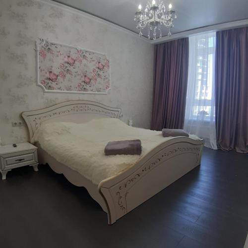 a bedroom with a large bed and a chandelier at 36 жемчужина. Аркадия in Odesa