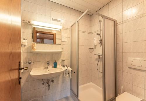 a bathroom with a sink and a shower at Gästehaus Huber Frühstückspension in Schladming