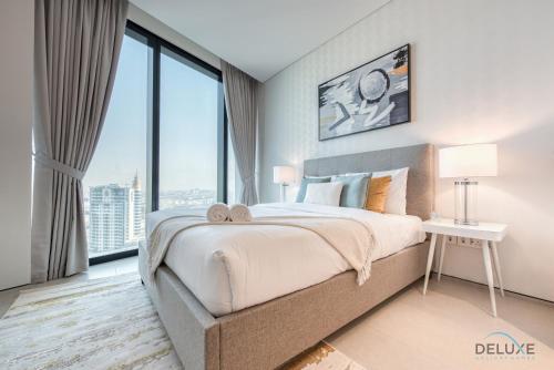 ein Schlafzimmer mit einem großen Bett und einem großen Fenster in der Unterkunft Posh 1BR at The Address Residences in JBR by Deluxe Holiday Homes in Dubai