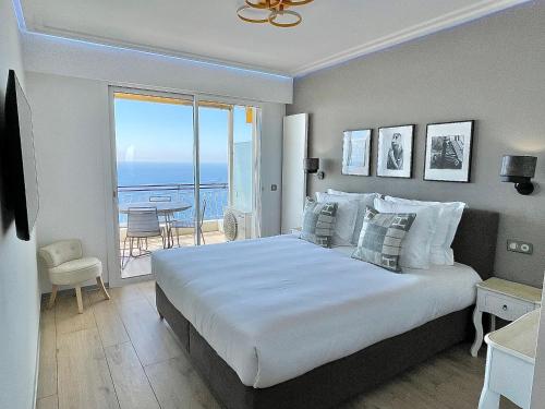 una camera con un grande letto e un balcone di MyBlueVista LUXURY PANORAMIC SEA VIEW APARTMENTS CAP D AIL NEAR MONACO a Cap d'Ail