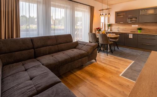 a living room with a couch and a kitchen at Villa Gloria Rooms & Apartments in Donovaly