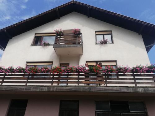 a building with flower boxes on the balcony at Apartman Draga in Mokra Gora