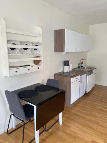 uma cozinha com mesa e cadeiras num quarto em Katthagen em Skara