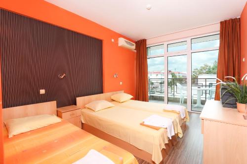 a hotel room with two beds and a balcony at La Piazza Family Hotel in Sunny Beach