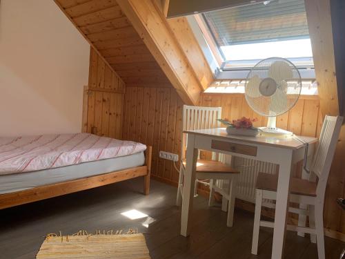 a bedroom with a bed and a desk with a fan at Haus Valentina in Waldsolms