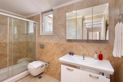 a bathroom with a sink and a shower and a toilet at Onix Apart Hotel in Antalya