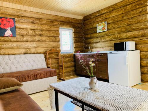een woonkamer met een bank, een tafel en een koelkast bij Chalet Vedmezhe in Polyana