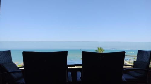 a group of chairs with the ocean in the background at Luxury Beach Apartment in Qerret in Golem