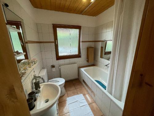 een badkamer met een bad, een toilet en een wastafel bij Haus im Grünen in Trendelburg