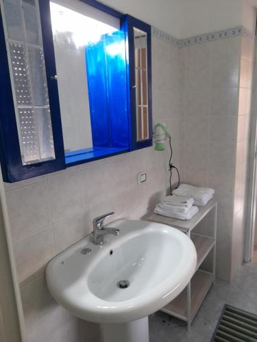 a white sink in a bathroom with a blue window at Ely Sea in Belvedere Marittimo