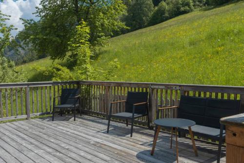 three chairs and a table on a wooden deck at Hörandlhof in Aigen im Ennstal