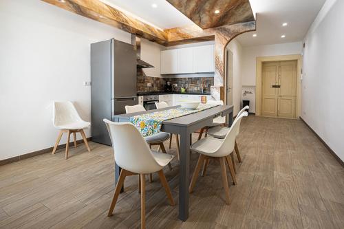 a kitchen with a table and chairs in a room at Mola’s Square House in Mola di Bari