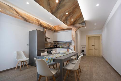 a kitchen and dining room with a table and chairs at Mola’s Square House in Mola di Bari