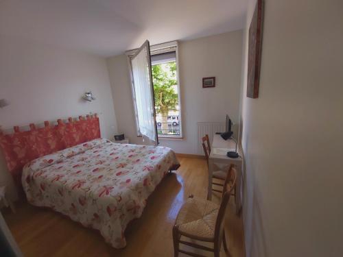 a bedroom with a bed and a window at Le Relais de la Tour in Figeac