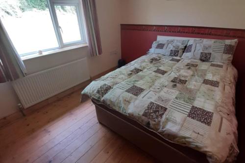 ein Schlafzimmer mit einem Bett mit einer Decke darauf in der Unterkunft Innishmore Island Farmhouse in Cavan