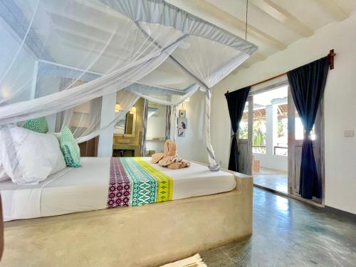 a bedroom with a bed with a canopy at Villa Huruma in Paje