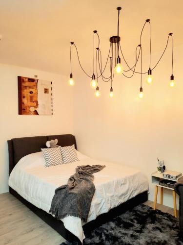 a bedroom with a bed with a chandelier at Amaia Steps Nuvali fully furnished unit with swimming pool view near Carmelray Pitland in Calamba