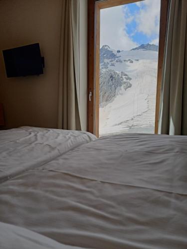 a bed in a room with a view of a mountain at CAPANNA PRESENA in Passo del Tonale
