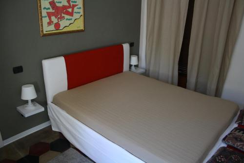 un letto con testiera rossa e bianca in una camera da letto di Melograni 28 a Omegna