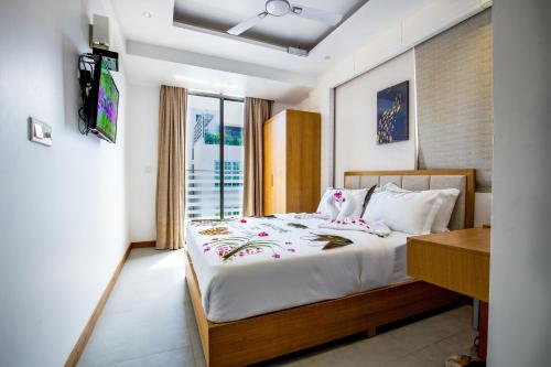 Araamview في هولهومالي: غرفة نوم فيها سرير وتلفزيون