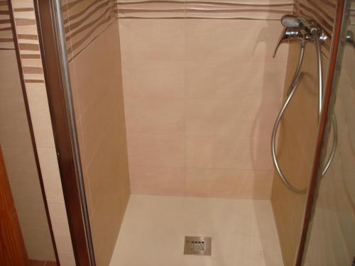 a shower with a glass door in a bathroom at Pensión sol y playa in Carboneras