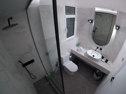 uma casa de banho com um WC, um lavatório e um espelho. em Acropolis Museum Apartment em Atenas