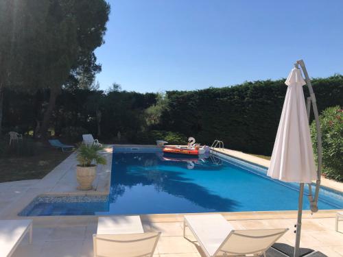 - une piscine avec un bateau et un parasol dans l'établissement Le Paradis d’Anny, à Rouffiac-dʼAude