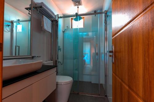 a bathroom with a shower and a toilet and a sink at Araamview in Hulhumale