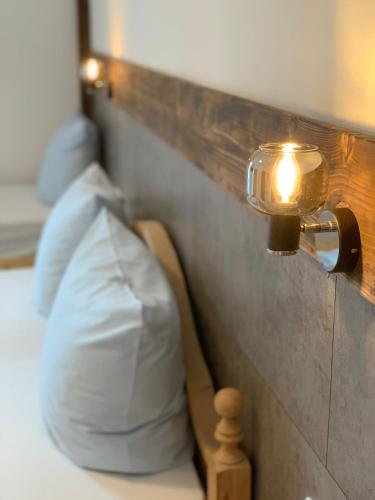 a light on a wall next to a bed at Gasthof Löwen in Pfronten