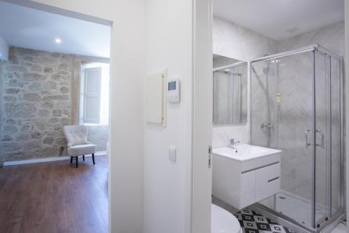 a white bathroom with a shower and a sink at Solar Valadim - serviced apartments in Castelo Branco