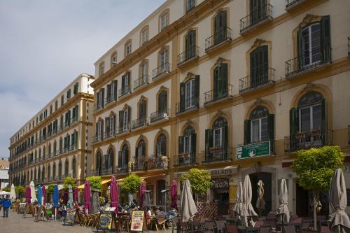 un bâtiment avec des tables et des parasols devant lui dans l'établissement Residencia Universitaria San José, à Malaga