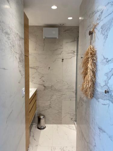baño con ducha a ras de suelo y puerta de cristal en Lostane - Villa sur le toit, en Grimaud