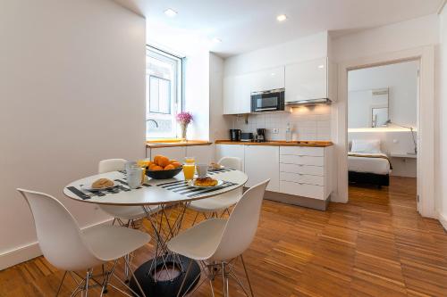 a kitchen and dining room with a table and chairs at Portas Do Bairro in Lisbon