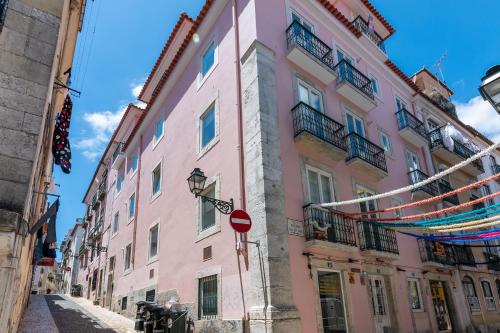 a pink building on a street with a do not enter sign at Portas Do Bairro in Lisbon
