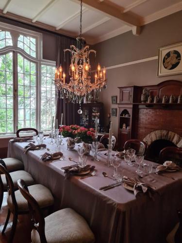 a dining room with a long table and a chandelier at The Great Gatsby Houghton in Johannesburg
