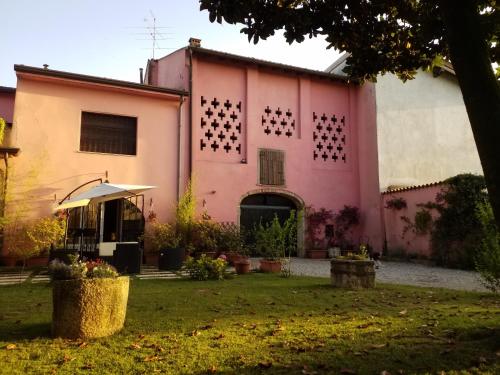 a pink house with a garden in front of it at Residenza La Dimora ImPerfetta in Salionze