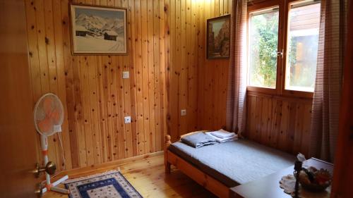 sypialnia z drewnianymi ścianami i łóżkiem z oknem w obiekcie A piece of Heaven! Wooden house with garden! w Chios