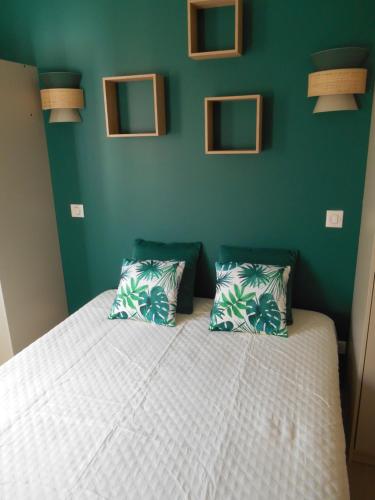 um quarto com uma cama branca e uma parede verde em MAISON D'AELA em Assérac