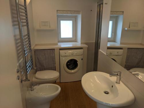 ein Badezimmer mit einer Waschmaschine und einem Waschbecken in der Unterkunft Lovely Stone House Conversano Puglia in Conversano