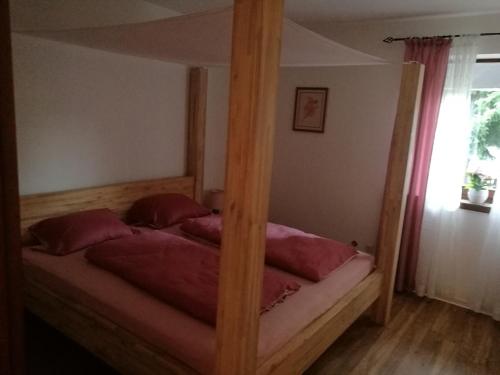 ein Bett mit einem Holzrahmen in einem Schlafzimmer in der Unterkunft Erholsames wohnen am Sonnenberg in Feldkirchen in Kärnten