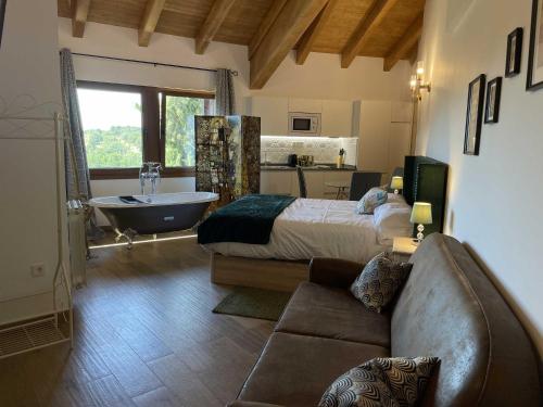 una camera con letto, vasca e divano di El Bulín de Montejo a Montejo de la Sierra